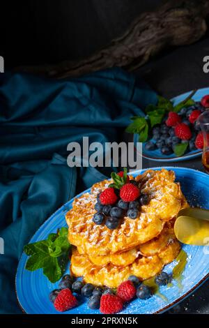 Einfache süße Waffeln mit Himbeeren und Heidelbeeren Stockfoto