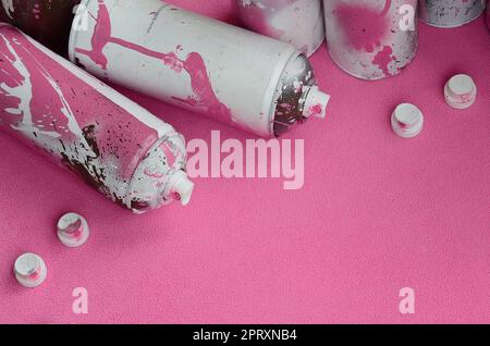 Einige rosa Aerosol Spraydosen und Düsen mit farbspritzer liegt auf einer Decke aus weichem, flauschigen Rosa fleece Stoff. Klassische weibliches Design col Stockfoto