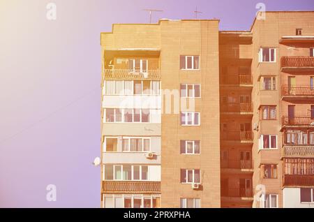 Detaillierte Foto von mehrstöckigen Wohnhaus mit vielen Balkonen und Fenstern. Herbergen für die armen Menschen in Russland und der Ukraine in einem beschädigten con Stockfoto