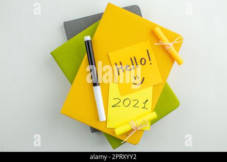 Hallo von oben und auf Haftnotizen geschrieben Schwarzer Marker auf bunten Notizbüchern auf weißem Hintergrund Stockfoto