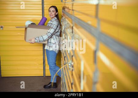 Seitenansicht eines jungen Weibchens, das die Schachtel mit Waren hält Stockfoto