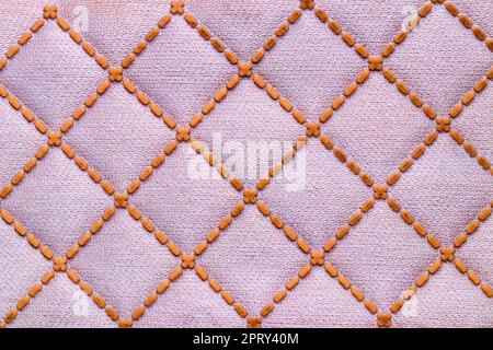 Polyester-Hintergrundstruktur. Nahaufnahme des farbenfrohen rosa-gelben Kunstfasermusters für Textilien, Schuhe, Taschen oder andere Kleidungsstücke. Makro. Stockfoto