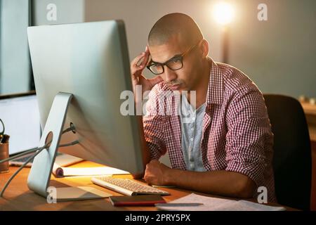 Er weiß, dass er jede Herausforderung meistern kann. Ein junger Designer, der lange in einem Büro arbeitet Stockfoto