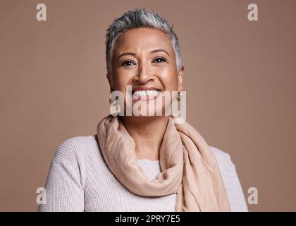 Gesicht, Mode und Schönheit mit einer Seniorin im Studio auf braunem Hintergrund, um zeitgenössischen Stil zu fördern. Portait, modisch und trendig mit einer Matte Stockfoto