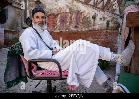 Porträt eines muslimischen Mannes, der auf einem Stuhl in den Tetouan-Gerbereien sitzt. Stockfoto