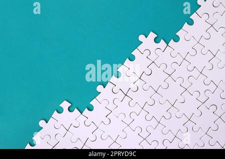 Fragment eines gefalteten weißen Puzzle auf dem Hintergrund einer blauen Kunststoff Oberfläche. Textur Foto mit Platz für Text kopieren Stockfoto