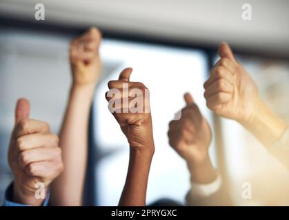 Das ist ein überwältigendes Ja von uns. Eine Gruppe von Geschäftsleuten, die eine "Daumen hoch" -Geste zeigen Stockfoto