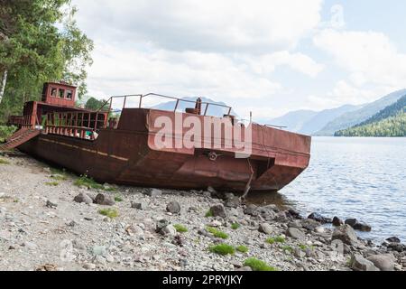 Schiffswrack, ein verlassenes russisches Schiff liegt an der Küste des Teletskoye Sees. Altai-Republik, Russland Stockfoto