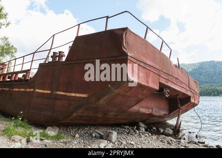 Verlassenes rusy-Schiff liegt an der Küste des Teletskoye-Sees. Altai-Republik, Russland Stockfoto