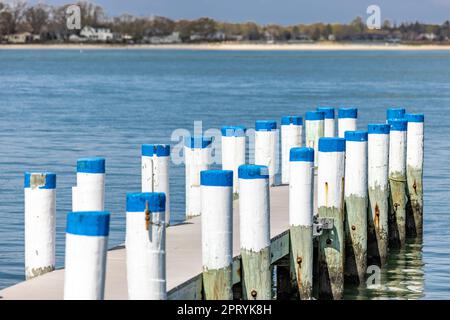 Ein überdachter Inseldock mit weißen Pfählen und blauen Kappen am Cresent Beach Stockfoto