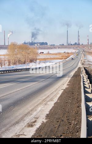 Blick auf die Chuysky Trakt Road und die Stadt Linyovo in der Region Nowosibirsk im Spätwinter Stockfoto