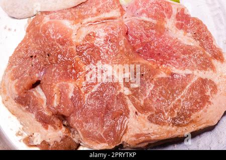 Rohes Schweinefleisch auf dem Teller, koreanisches traditionelles Schweinebauch-BBQ, japanisches Fleisch, Hot Pot oder Shabu im Restaurant, Grillgerichte Stockfoto