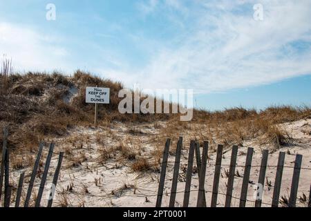 Halten Sie sich von dem Schild hinter einem Lattenzaun in den Sanddünen auf Fire Island fern. Stockfoto