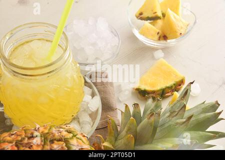 Details von frisch zubereiteter Ananascreme mit Obst und zerstoßenem Eis auf einem weißen Tisch. Erhöhte Aussicht. Horizontale Zusammensetzung. Stockfoto