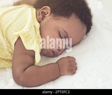 Sie schläft friedlich. Ein kleines Mädchen schläft zu Hause in einem Bett Stockfoto