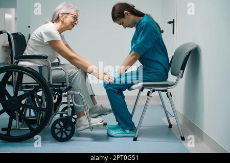 Ein netter alter Patient sitzt im Rollstuhl Stockfoto