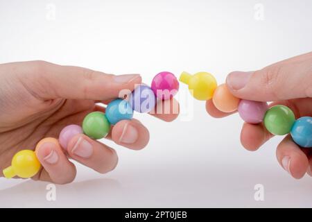 Hand, die Farbe Perlen mit Gesichtsausdruck auf weißem Hintergrund Stockfoto