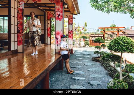 KANCHANABURI -THAILAND, MÄRZ 30 ,2023 : Unbekannte Touristen kommen zu Besuch und machen Fotos mit einem Restaurant und Café mit einem wunderschönen Garten Stockfoto