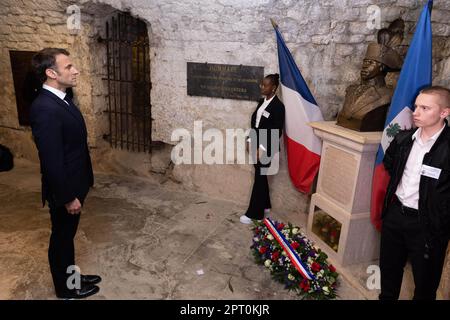 Der französische Präsident Emmanuel Macron würdigt vor einer Statue von Toussaint Louverture, dem Führer der haitianischen Unabhängigkeitsbewegung, bevor er das Chateau de Joux anlässlich einer Zeremonie anlässlich des 175. Jahrestages der Abschaffung der Sklaverei in Frankreich, in La Cluze-et-Mijoux, nahe Besancon, Ostfrankreich, am 27. April besucht; 2023. Macron besuchte das Chateau de Joux, um den 220. Todestag des französisch-haitianischen Generals Toussaint Louverture an dem Ort zu würdigen, an dem er bis zu seinem Tod inhaftiert war. Foto: Raphael Lafargue/ABACAPRESS.COM Stockfoto