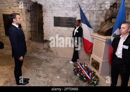 Der französische Präsident Emmanuel Macron würdigt vor einer Statue von Toussaint Louverture, dem Führer der haitianischen Unabhängigkeitsbewegung, bevor er das Chateau de Joux anlässlich einer Zeremonie anlässlich des 175. Jahrestages der Abschaffung der Sklaverei in Frankreich, in La Cluze-et-Mijoux, nahe Besancon, Ostfrankreich, am 27. April besucht; 2023. Macron besuchte das Chateau de Joux, um den 220. Todestag des französisch-haitianischen Generals Toussaint Louverture an dem Ort zu würdigen, an dem er bis zu seinem Tod inhaftiert war. Foto: Raphael Lafargue/ABACAPRESS.COM Stockfoto