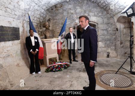 Der französische Präsident Emmanuel Macron würdigt vor einer Statue von Toussaint Louverture, dem Führer der haitianischen Unabhängigkeitsbewegung, bevor er das Chateau de Joux anlässlich einer Zeremonie anlässlich des 175. Jahrestages der Abschaffung der Sklaverei in Frankreich, in La Cluze-et-Mijoux, nahe Besancon, Ostfrankreich, am 27. April besucht; 2023. Macron besuchte das Chateau de Joux, um den 220. Todestag des französisch-haitianischen Generals Toussaint Louverture an dem Ort zu würdigen, an dem er bis zu seinem Tod inhaftiert war. Foto: Raphael Lafargue/ABACAPRESS.COM Stockfoto