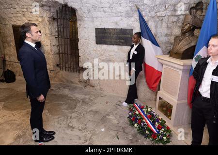 Der französische Präsident Emmanuel Macron würdigt vor einer Statue von Toussaint Louverture, dem Führer der haitianischen Unabhängigkeitsbewegung, bevor er das Chateau de Joux anlässlich einer Zeremonie anlässlich des 175. Jahrestages der Abschaffung der Sklaverei in Frankreich, in La Cluze-et-Mijoux, nahe Besancon, Ostfrankreich, am 27. April besucht; 2023. Macron besuchte das Chateau de Joux, um den 220. Todestag des französisch-haitianischen Generals Toussaint Louverture an dem Ort zu würdigen, an dem er bis zu seinem Tod inhaftiert war. Foto: Raphael Lafargue/ABACAPRESS.COM Stockfoto