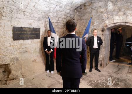 Der französische Präsident Emmanuel Macron würdigt vor einer Statue von Toussaint Louverture, dem Führer der haitianischen Unabhängigkeitsbewegung, bevor er das Chateau de Joux anlässlich einer Zeremonie anlässlich des 175. Jahrestages der Abschaffung der Sklaverei in Frankreich, in La Cluze-et-Mijoux, nahe Besancon, Ostfrankreich, am 27. April besucht; 2023. Macron besuchte das Chateau de Joux, um den 220. Todestag des französisch-haitianischen Generals Toussaint Louverture an dem Ort zu würdigen, an dem er bis zu seinem Tod inhaftiert war. Foto: Raphael Lafargue/ABACAPRESS.COM Stockfoto