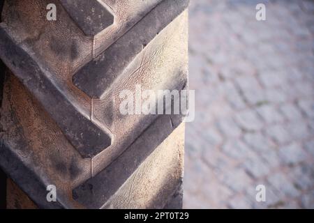 Nahaufnahme eines großen gebrauchten Traktorreifens mit Kopierfläche rechts. Stockfoto