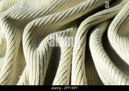 Stoffstruktur eines weichen gelben Strickpulvers. Makrobild der Bindungsstruktur in Garnen Stockfoto