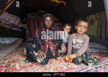 Antakya, Türkei. 27. April 2023. Eine alte Frau sitzt mit ihren Enkeln in einem Zelt, wo sie seit dem Erdbeben leben. Große Teile der Stadt wurden bei dem Erdbeben am 6. Februar vollständig zerstört. Kredit: Boris Roessler/dpa/Alamy Live News Stockfoto