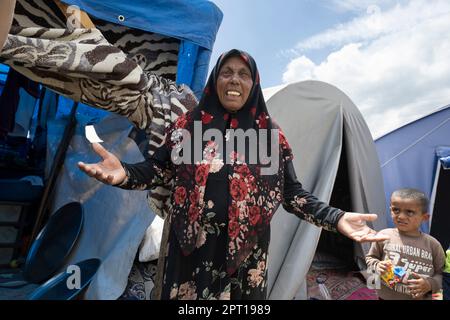 Antakya, Türkei. 27. April 2023. Eine alte Frau steht mit einem ihrer Enkel vor einem Zelt, in dem sie seit dem Erdbeben lebt. Große Teile der Stadt wurden bei dem Erdbeben am 6. Februar vollständig zerstört. Kredit: Boris Roessler/dpa/Alamy Live News Stockfoto