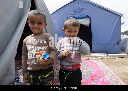 Antakya, Türkei. 27. April 2023. Zwei Jungen stehen vor einem Zelt, in dem sie seit dem Erdbeben mit ihrer Großmutter zusammenleben. Große Teile der Stadt wurden bei dem Erdbeben am 6. Februar vollständig zerstört. Kredit: Boris Roessler/dpa/Alamy Live News Stockfoto