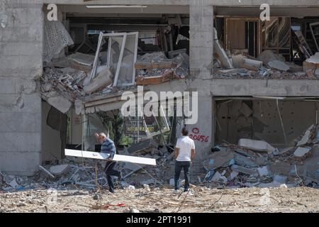 Antakya, Türkei. 27. April 2023. Die Bewohner gehen an einer zerstörten Reihe von Häusern entlang. Große Teile der Stadt wurden bei dem Erdbeben am 6. Februar vollständig zerstört. Kredit: Boris Roessler/dpa/Alamy Live News Stockfoto