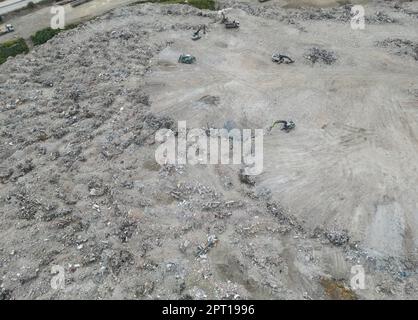 Antakya, Türkei. 27. April 2023. Bagger sind damit beschäftigt, die Trümmer zerstörter Häuser, die auf einem riesigen Gebiet am Stadtrand von Antakya abgeladen wurden, auszugleichen (Luftaufnahme durch eine Drohne). Große Teile der Stadt wurden durch das Erdbeben am 6. Februar vollständig zerstört. Kredit: Boris Roessler/dpa/Alamy Live News Stockfoto