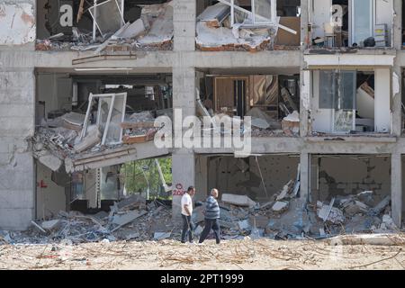 Antakya, Türkei. 27. April 2023. Die Bewohner gehen an einer zerstörten Reihe von Häusern entlang. Große Teile der Stadt wurden bei dem Erdbeben am 6. Februar vollständig zerstört. Kredit: Boris Roessler/dpa/Alamy Live News Stockfoto