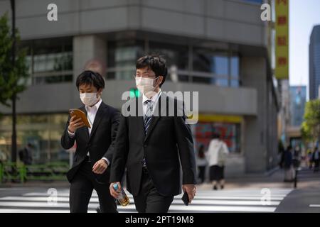 Tokio, Japan. 27. April 2023. Japanische Geschäftsleute mit Gesichtsmasken gehen über eine Kreuzung im Zentrum von Tokio. (Kreditbild: © Stanislav Kogiku/SOPA Images via ZUMA Press Wire) NUR REDAKTIONELLE VERWENDUNG! Nicht für den kommerziellen GEBRAUCH! Stockfoto