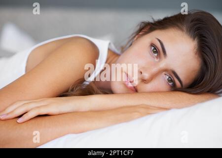 Heute habe ich viel im Kopf... Eine schöne junge Frau, die traurig aussieht, als sie auf ihrem Bett liegt Stockfoto
