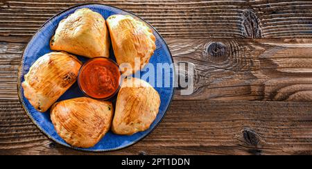 Zusammensetzung mit einem Teller aus im Ofen gebackenen Pierogi Stockfoto