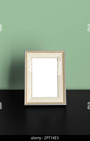Vertikaler Rahmen Modell steht auf einem Holztisch im Innenraum des Büroraums auf grünem Wandhintergrund Stockfoto