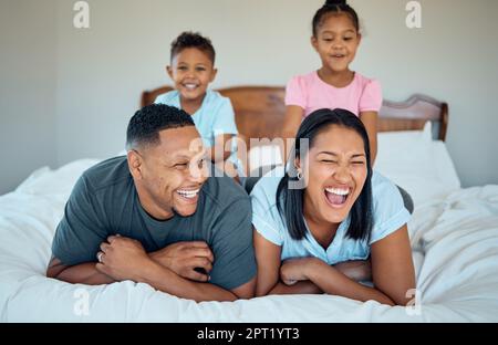 Glücklich, entspannen und lächeln Sie mit der Familie im Schlafzimmer für lustig, Bonding und am Morgen aufwachen. Wochenende, aufgeregt und Zuneigung mit Eltern und Kindern Stockfoto