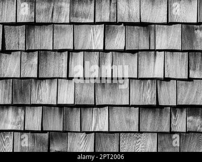 Formatfüllende Ansicht einer Wand aus schwarz-weißen Holzschindeln. Stockfoto