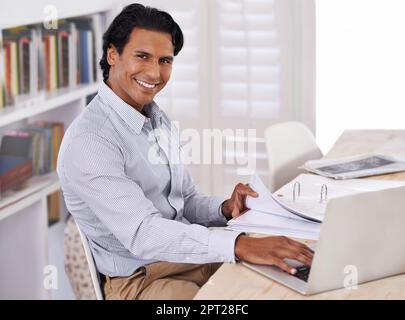 Es ist schwer, vom Internet fernzuhalten. Ein gutaussehender Mann, der zu Hause an einem Notebook arbeitet Stockfoto