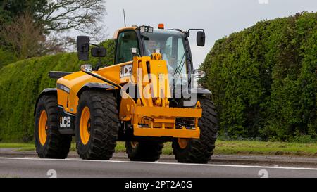 Bicester, Oxon, Großbritannien - April 23. 2023. JCB-Baumaschinen, die auf einer englischen Landstraße unterwegs sind Stockfoto