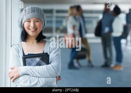 Ich will die beste Ausbildung. Porträt eines lächelnden asiatischen Studenten mit Freunden im Hintergrund Stockfoto