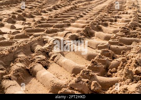 Reifenspuren auf Sand auf der Baustelle. Ansicht aus niedrigem Winkel. Selektiver Fokus. Stockfoto