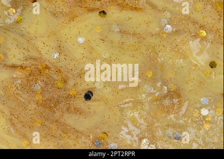 Abstrakte, goldfarbene Schleimhintergrund-Makro-Nahaufnahme Stockfoto