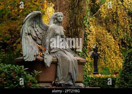 Engel mit ausgebreiteten Flügeln auf einem Friedhof in Herbststimmung Stockfoto