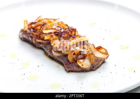 Steak mit karamellisierten Zwiebeln bedeckt Stockfoto