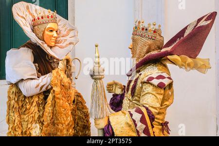 Venedig Karnevalskostümierte Teilnehmer posieren in mittelalterlichen barocken Kostümen und goldenen Masken, Venedig, Italien Kredit: Imageplotter/Alamy Live News Stockfoto