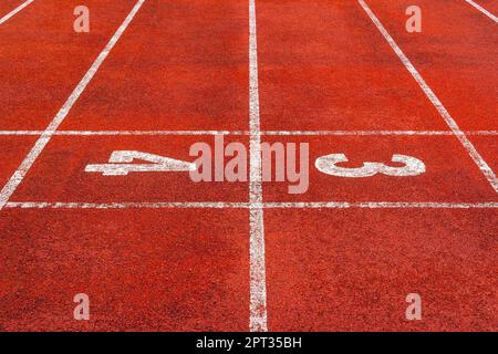 Beginne mit den Zahlen 3 und 4 auf der Laufbahn oder der Sportlerbahn im Stadion. Die Laufstrecke ist eine gummierte künstliche Lauffläche für die Laufstrecke und Stockfoto